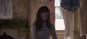 Movie still from “True History of the Kelly Gang” (2019), directed by Justin Kurzel – A woman in a white dress is looking down; Medium shot, Over the shoulder angle