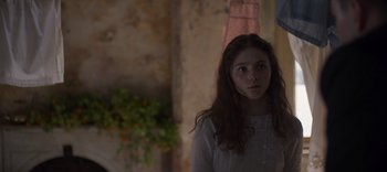 Movie still from “True History of the Kelly Gang” (2019), directed by Justin Kurzel – A woman standing in a room looking at the camera; Close Up shot, Over the shoulder angle