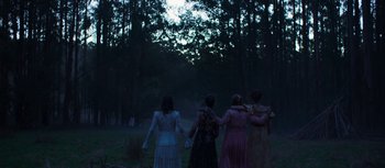 Movie still from “True History of the Kelly Gang” (2019), directed by Justin Kurzel – A group of people standing in a field at night; Wide shot, High angle