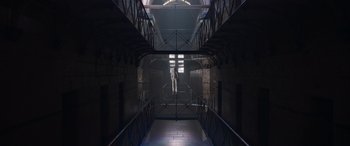 Movie still from “True History of the Kelly Gang” (2019), directed by Justin Kurzel – A man standing in a dark room in a jail cell; Extreme Wide shot, Low angle