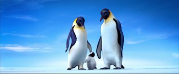 Movie still from “Happy Feet” (2006), directed by Warren Coleman – Two adult penguins and a baby penguin standing in the snow; Wide shot, Low angle