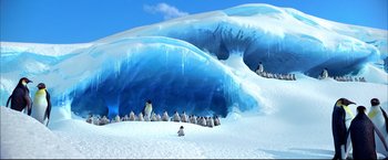 Movie still from “Happy Feet” (2006), directed by Warren Coleman – A group of penguins are gathered in the snow near an ice cave; Extreme Wide shot, High angle