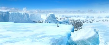 Movie still from “Happy Feet” (2006), directed by Warren Coleman – A penguin sitting on top of a snow covered slope; Extreme Wide shot, High angle