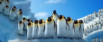 Movie still from “Happy Feet” (2006), directed by Warren Coleman – A group of penguins standing on top of a snow covered ground; Wide shot, Low angle