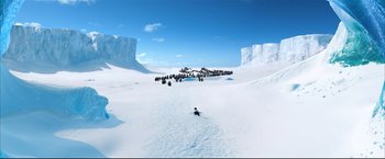 Movie still from “Happy Feet” (2006), directed by Warren Coleman – A group of penguins walking across a snow covered ground; Extreme Wide shot, High angle