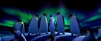Movie still from “Happy Feet” (2006), directed by Warren Coleman – A group of penguins standing on top of a snow covered ground; Wide shot, Low angle