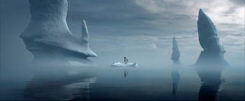 Movie still from “Happy Feet” (2006), directed by Warren Coleman – A penguin is sitting on an ice floe in the middle of the ocean; Extreme Wide shot, Low angle