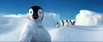 Movie still from “Happy Feet” (2006), directed by Warren Coleman – A group of penguins standing on top of a snow covered slope; Extreme Wide shot, Low angle