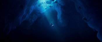 Movie still from “Happy Feet” (2006), directed by Warren Coleman – An underwater view of a person swimming in the ocean; Extreme Wide shot, Overhead angle