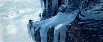Movie still from “Happy Feet” (2006), directed by Warren Coleman – A man standing next to a cliff with icicles on it; Extreme Wide shot, Low angle