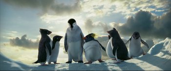 Movie still from “Happy Feet” (2006), directed by Warren Coleman – A group of penguins standing on top of a snow covered slope; Medium shot, Low angle