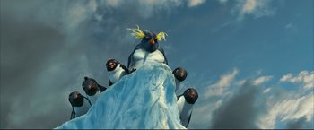 Movie still from “Happy Feet” (2006), directed by Warren Coleman – A group of penguins sitting on top of a snow covered hill; Medium shot, Low angle