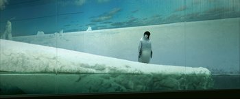 Movie still from “Happy Feet” (2006), directed by Warren Coleman – A penguin standing on a snow covered ground; Wide shot, Low angle