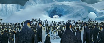 Movie still from “Happy Feet” (2006), directed by Warren Coleman – A group of penguins standing on top of a snow covered ground; Extreme Wide shot, High angle