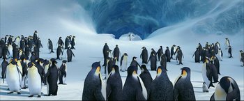 Movie still from “Happy Feet” (2006), directed by Warren Coleman – A group of penguins standing on top of a snow covered ground; Extreme Wide shot, High angle