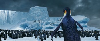 Movie still from “Happy Feet” (2006), directed by Warren Coleman – Many penguins that are standing in the snow; Extreme Wide shot, High angle