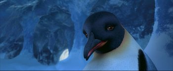 Movie still from “Happy Feet” (2006), directed by Warren Coleman – A black and white bird is looking at the camera; Close Up shot, High angle