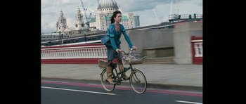 Movie still from “Happy-Go-Lucky” (2008), directed by Mike Leigh – A woman riding a bicycle down a street; Wide shot, Low angle