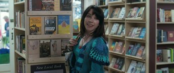 Movie still from “Happy-Go-Lucky” (2008), directed by Mike Leigh – A woman standing in front of a book store; Close Up shot, Over the shoulder angle