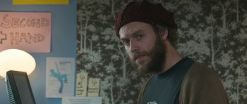 Movie still from “Happy-Go-Lucky” (2008), directed by Mike Leigh – A man with a beard wearing a brown hat; Close Up shot, Over the shoulder angle