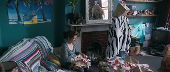 Movie still from “Happy-Go-Lucky” (2008), directed by Mike Leigh – A woman sitting in front of a fire place; Wide shot, High angle