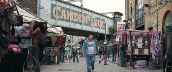 Movie still from “Happy-Go-Lucky” (2008), directed by Mike Leigh – A group of people walking down a street; Wide shot, High angle