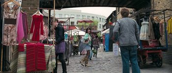 Movie still from “Happy-Go-Lucky” (2008), directed by Mike Leigh – A group of people walking down a street; Wide shot, Over the shoulder angle