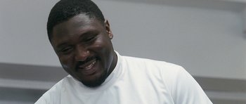 Movie still from “Happy-Go-Lucky” (2008), directed by Mike Leigh – A person wearing a white t - shirt smiling; Close Up shot, Low angle