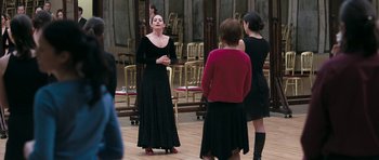 Movie still from “Happy-Go-Lucky” (2008), directed by Mike Leigh – A group of people standing around in a room; Medium shot, Over the shoulder angle
