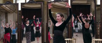 Movie still from “Happy-Go-Lucky” (2008), directed by Mike Leigh – A woman in a black top is holding her hands up; Medium shot, Low angle