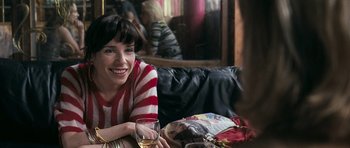 Movie still from “Happy-Go-Lucky” (2008), directed by Mike Leigh – A woman sitting at a table holding a glass of wine; Close Up shot, Over the shoulder angle