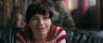 Movie still from “Happy-Go-Lucky” (2008), directed by Mike Leigh – A person holding a glass of wine; Close Up shot, Low angle