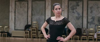 Movie still from “Happy-Go-Lucky” (2008), directed by Mike Leigh – A woman in a black dress posing for a picture; Close Up shot, Over the shoulder angle