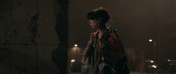 Movie still from “Happy-Go-Lucky” (2008), directed by Mike Leigh – A woman walking down a street holding a purse; Medium shot, Over the shoulder angle