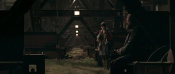 Movie still from “Happy-Go-Lucky” (2008), directed by Mike Leigh – A man standing in a barn with a dog; Wide shot, Over the shoulder angle