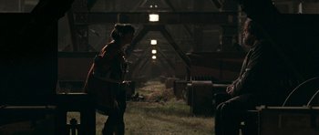 Movie still from “Happy-Go-Lucky” (2008), directed by Mike Leigh – A person standing in a dark room with luggage; Wide shot, Over the shoulder angle