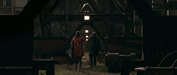 Movie still from “Happy-Go-Lucky” (2008), directed by Mike Leigh – Two people are walking in a dark building; Extreme Wide shot, High angle