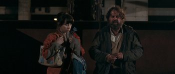 Movie still from “Happy-Go-Lucky” (2008), directed by Mike Leigh – A man and a woman standing next to each other; Medium shot, Over the shoulder angle