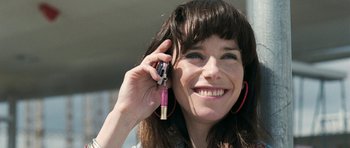 Movie still from “Happy-Go-Lucky” (2008), directed by Mike Leigh – A woman holding a cell phone up to her ear; Close Up shot, Low angle