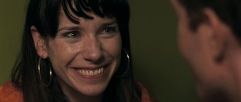 Movie still from “Happy-Go-Lucky” (2008), directed by Mike Leigh – A person smiling for the camera; Close Up shot, Over the shoulder angle