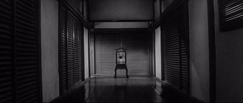 Movie still from “Harakiri” (1962), directed by Masaki Kobayashi – An empty chair sits in the middle of a room; Extreme Wide shot, High angle