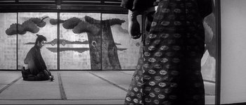 Movie still from “Harakiri” (1962), directed by Masaki Kobayashi – A person standing in front of a window with trees in the background; Wide shot, Low angle