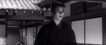 Movie still from “Harakiri” (1962), directed by Masaki Kobayashi – A man wearing a black robe standing in a room; Close Up shot, Low angle