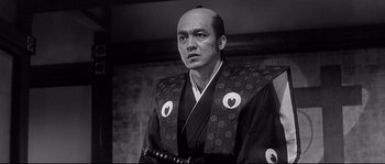 Movie still from “Harakiri” (1962), directed by Masaki Kobayashi – A man in a black and white photo wearing a kimono; Close Up shot, Low angle