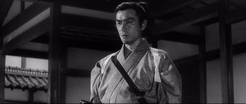 Movie still from “Harakiri” (1962), directed by Masaki Kobayashi – A man in a kimono holding a sword in his hand; Close Up shot, Low angle