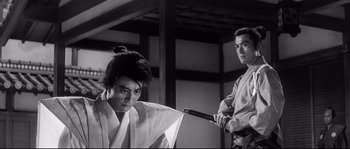 Movie still from “Harakiri” (1962), directed by Masaki Kobayashi – A man holding a sword in front of another man; Medium shot, Low angle
