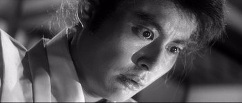 Movie still from “Harakiri” (1962), directed by Masaki Kobayashi – Black and white photograph of a young man's face; Extreme Close Up shot, Low angle
