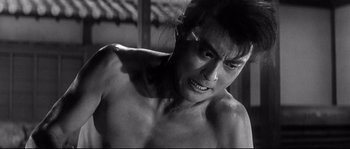 Movie still from “Harakiri” (1962), directed by Masaki Kobayashi – A man with a shaved head is looking at the camera; Close Up shot, Low angle