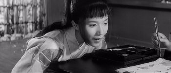 Movie still from “Harakiri” (1962), directed by Masaki Kobayashi – A young asian woman looking at a cell phone on a table; Close Up shot, High angle