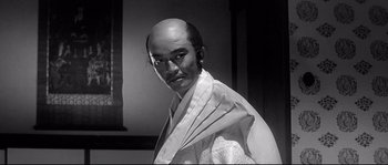Movie still from “Harakiri” (1962), directed by Masaki Kobayashi – A man in a white robe with a bald head; Close Up shot, Low angle